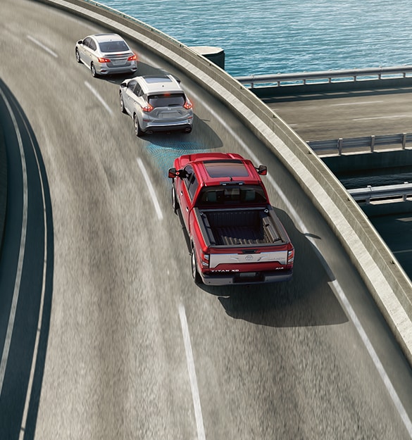 2024 Nissan TITAN in red on the highway showing Intelligent Forward Collision Warning technology 