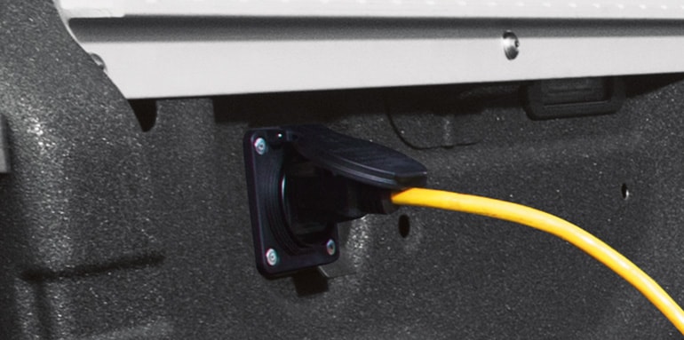 2024 Nissan TITAN bed showing yellow cord plugged in to 120-volt outlet in 