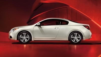 Nissan Altima Coupe driver's side profile in white set against a red background