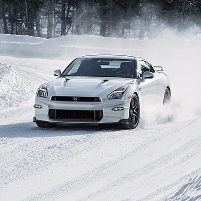 Nissan GT-R 2024 tomando una curva en la nieve.