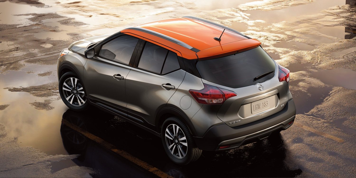 Nissan Kicks in Gunmetal with Monarch Orange roof parked on wet pavement