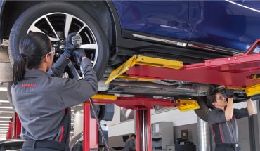 Nissan mechanic adjusting vehicle tire alignment