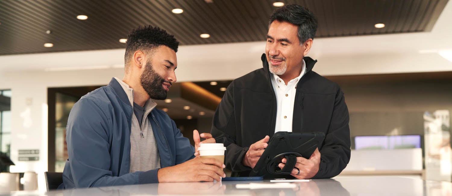 Two men viewing Nissan Business Fleet program enrollment on tablet