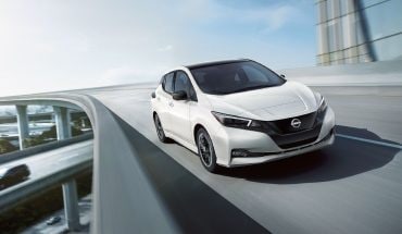 2023 Nissan LEAF driving on curved highway overpass.