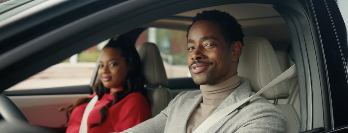 Jay Ellis and Dope Candi smiling happily while seated inside a Nissan Ariya car