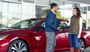 Nissan Saleperson Handing Over Keyfob To Customer