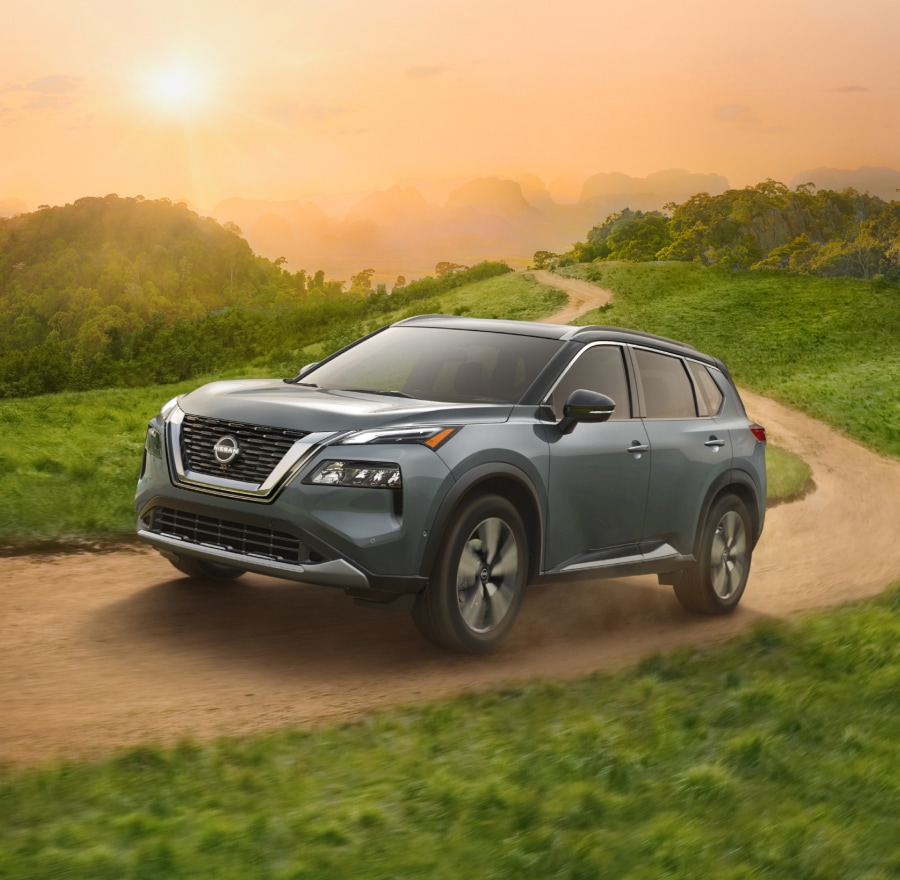 2024 Nissan Rogue, gray with black roof, navigating an unpaved road.