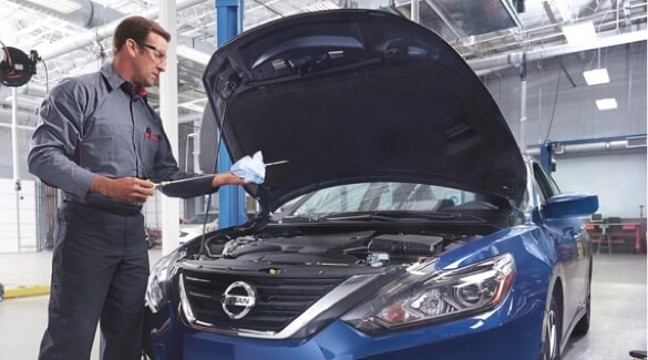 Nissan Technician Inspecting Car Oil