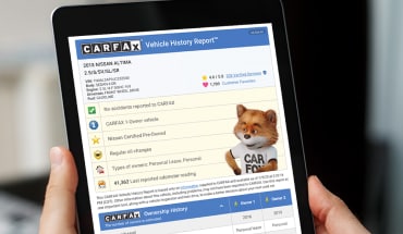 Person Researching CARFAX Vehicle History Report On Nissan Certified Pre-Owned Vehicle