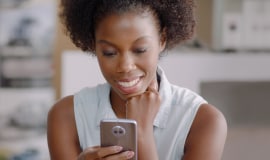 Woman smiling looking at smartphone