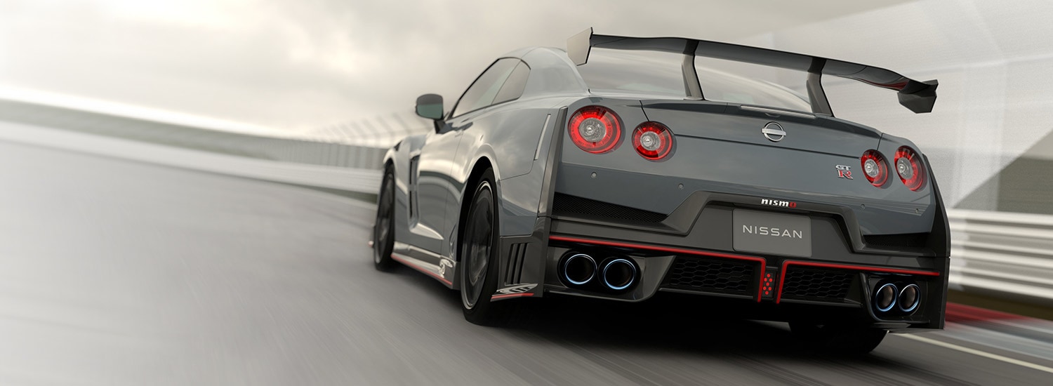 2024 Nissan GT-R in Stealth Gray with Appearance Package in 3/4 rear profile driving around a track