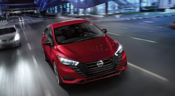 Red 2023 Nissan Versa driving on highway
