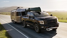 2021 Nissan TITAN on highway with canoe on top and towing an airstream
