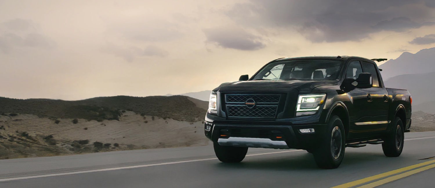 2021 Nissan TITAN Crew Cab in black on a highway at sunset