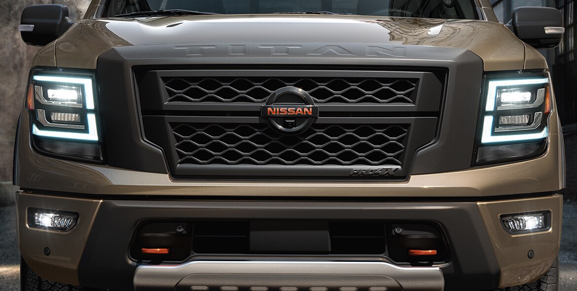 2021 Nissan TITAN in Baja Storm front view closeup with LED headlights on
