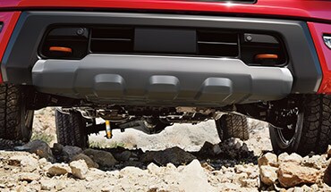 2022 Nissan Titan PRO-4X underside of truck climbing rocks with skid plate underneath.