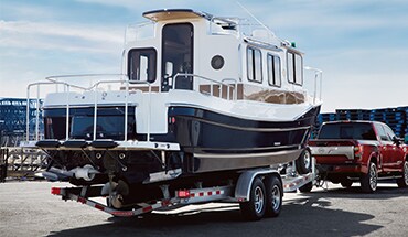 2023 Nissan TITAN towing a large boat illustrating remote trailer light check.