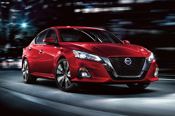 2022 Nissan Altima in red at night with LED headlights and fog lights.