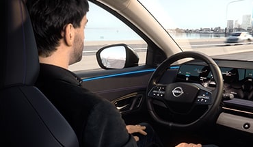 2023 Nissan Ariya person using hands-off driving to illustrate driver assist and safety technology features