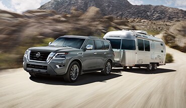 2023 Nissan Armada towing an airstream on mountain road.