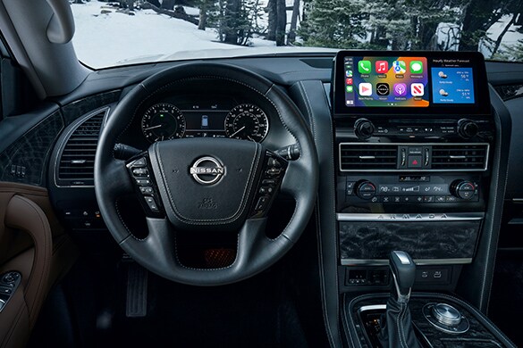 2023 Nissan Armada drivers view showing widescreen display, gauges, and steering wheel.