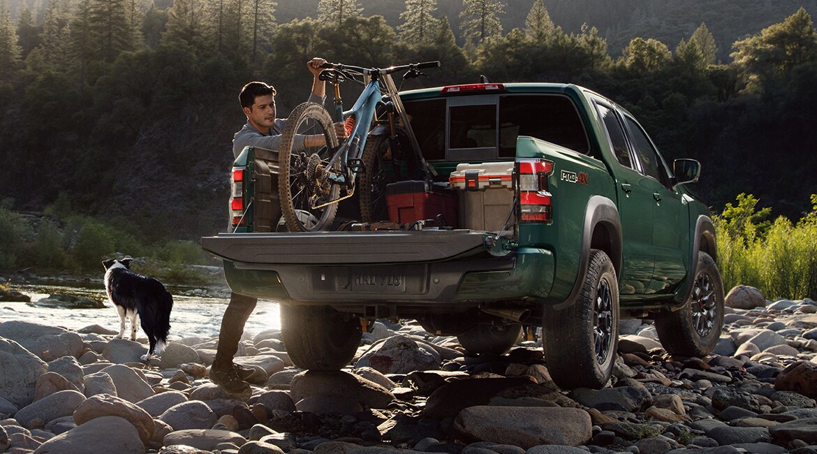 2022 Nissan Frontier bed with tailgate open with dog and bicycle inside.