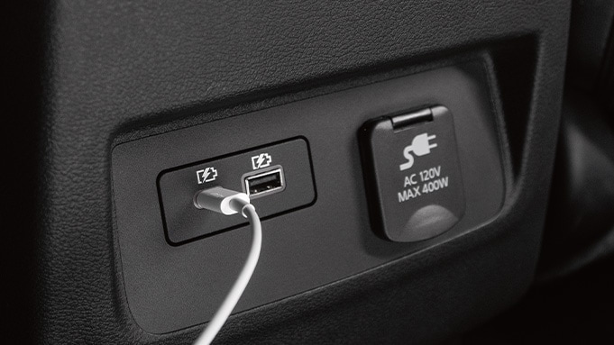 2024 Nissan Frontier detail view of USB ports & 120-volt outlet