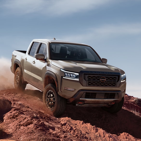 2024 Nissan Frontier driving down a rugged slope