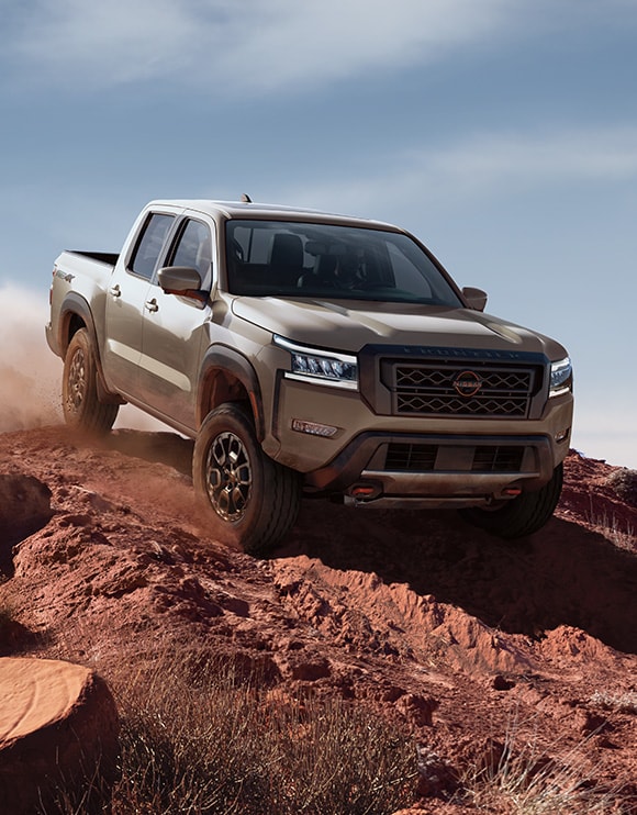 2024 Nissan Frontier driving down a rugged slope