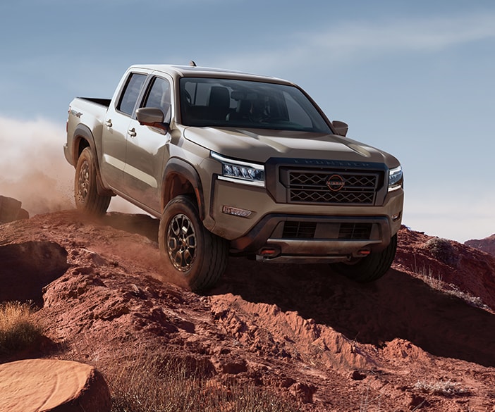 2024 Nissan Frontier PRO-4X driving down a rugged slope
