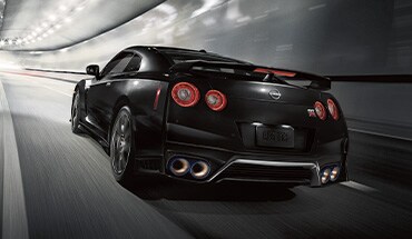 2023 Nissan GT-R rear view driving through well-lit tunnel.