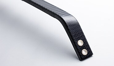 2023 Nissan GT-R closeup of a suspension strut bar made of carbon fiber.