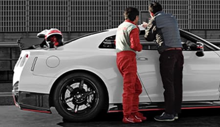 2023 Nissan GT-R NISMO in side view with engineers nearby.