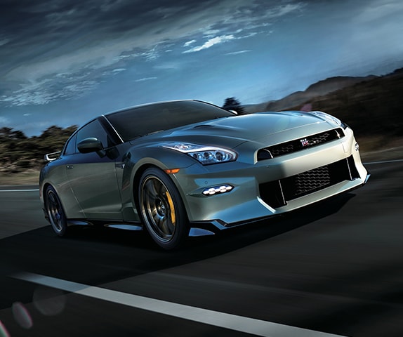 2024 Nissan GT-R in Millennium Jade in 3/4 front profile driving down a desert road.