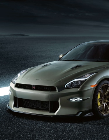 2024 Nissan GT-R T-spec in Millennium Jade in 3/4 profile on a gray background.