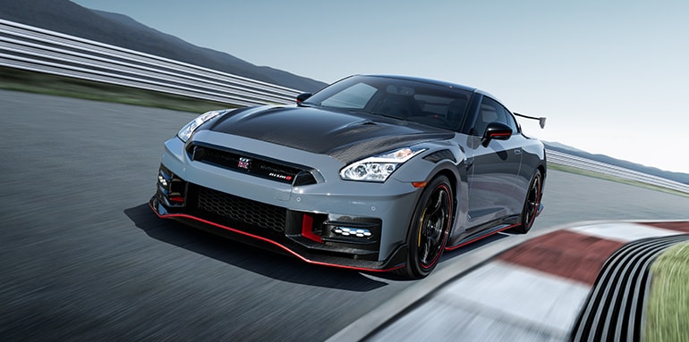 2024 Nissan GT-R NISMO front view while driving around a canted racetrack.