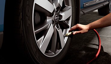 2023 Nissan Kicks person airing tire illustrating tire pressure monitoring system.