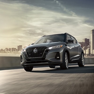 2024 Nissan Kicks in on a highway with city in background illustrating nimble handling