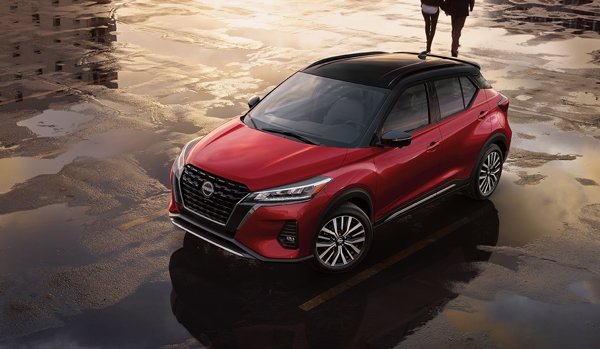 2024 Nissan Kicks in red parked on wet city streets illustrating 17 inch aluminum alloy wheels