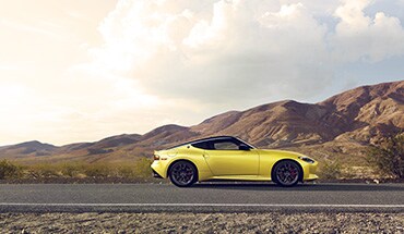 2023 Nissan Z in yellow with mountains in background.