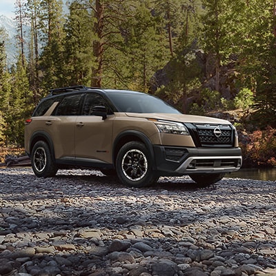 2024 Nissan Pathfinder Rock Creek on an empty riverbed showing front fascia and black accents.
