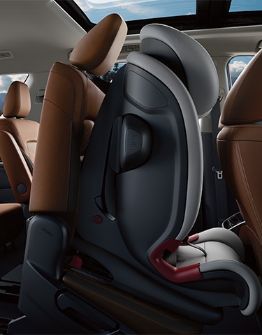 2024 Nissan Pathfinder interior view showing an empty child seat secured to a 2nd-row seat, which is tilted forward.
