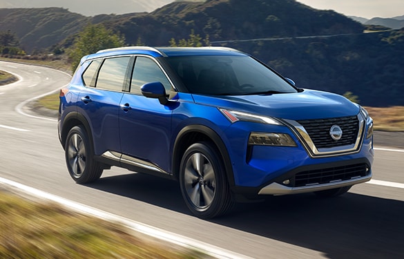 2022 Nissan Rogue in blue driving swiftly with mountains in the background illustrating horsepower and torque.
