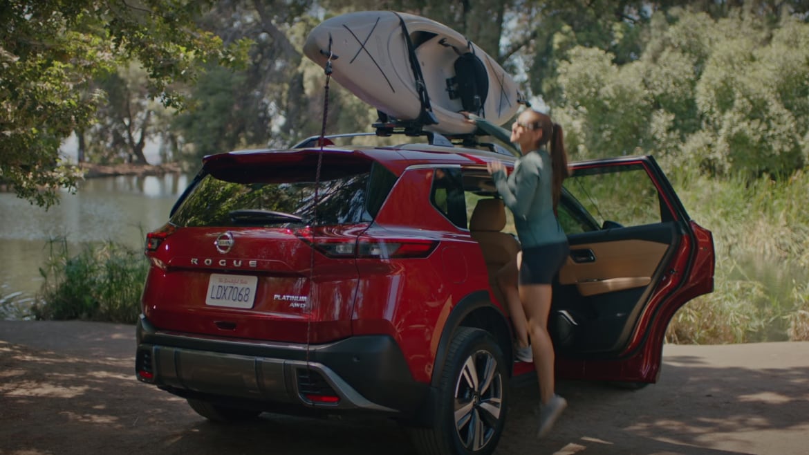 2023 Nissan Rogue red rear view, outfitted with top-mounted kayak