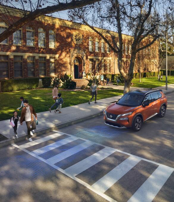 2023 Orange Nissan Rogue with Safety Shield 360 Technologies activated  as pedestrians cross road