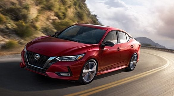 2022 Nissan Sentra in Scarlet Ember Tintcoat taking a curve on a mountain road.