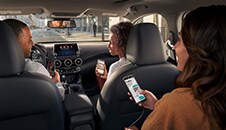 2022 Nissan Sentra interior with people using their smartphones to show device connectivity.