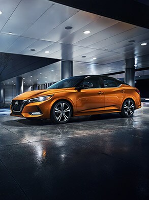 2023 Nissan Sentra in Two-tone Monarch Orange Metallic / Super Black at night near building.