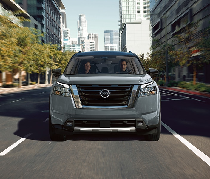 2024 Nissan Pathfinder front view driving down a city boulevard.